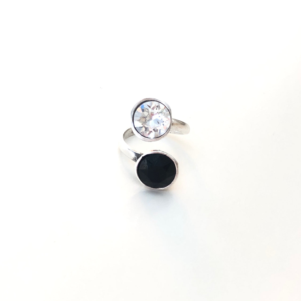 Anillo hecho a mano de Zamak con baño de plata adaptable y dos cristales de Swarovski®, uno negro y el otro blanco. Combínalo como quieras.