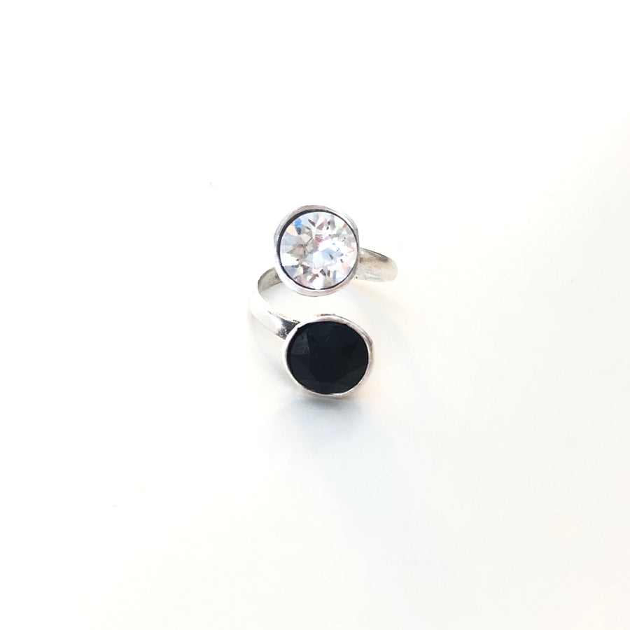 Anillo hecho a mano de Zamak con baño de plata adaptable y dos cristales de Swarovski®, uno negro y el otro blanco. Combínalo como quieras.
