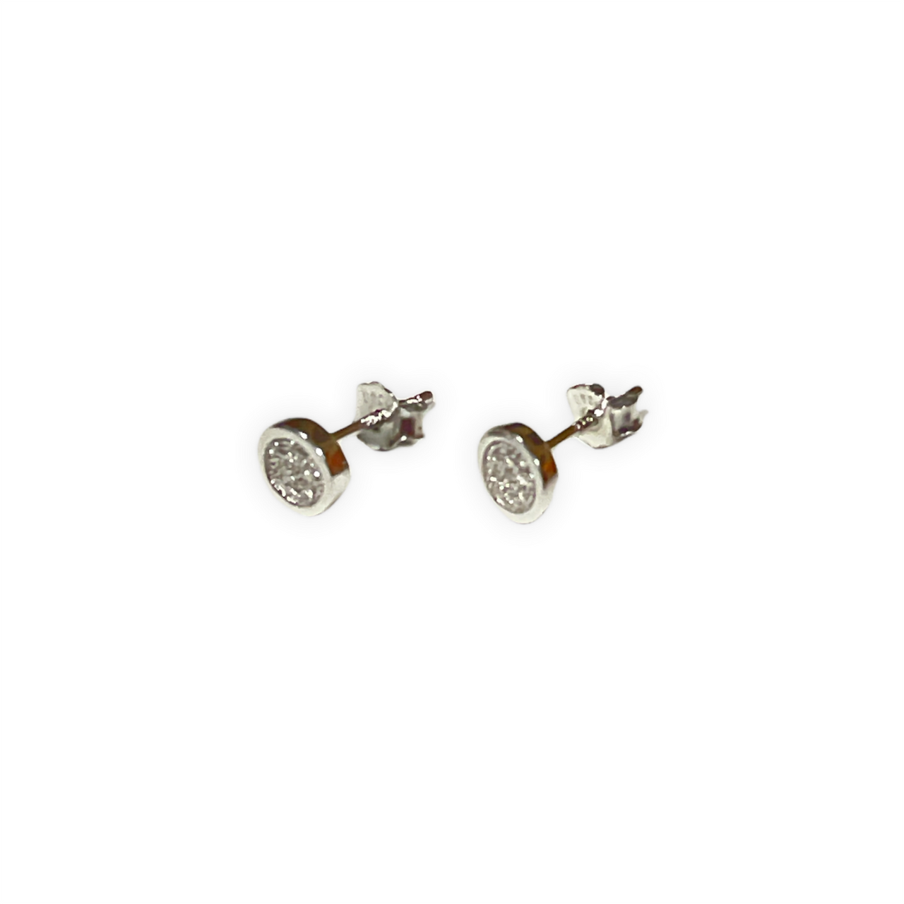 Espectaculares pendientes botón de plata de ley y circonitas blancas. Estos pendientes son perfectos para combinar con tu look favorito. Lateral