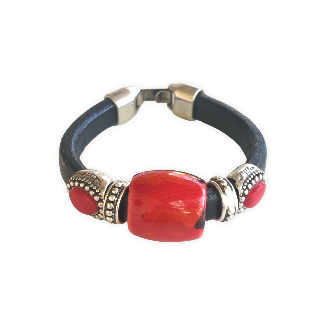 Elegante pulsera de cuero regaliz, con cuentas de Zamak con baño de plata y una espectacular cuenta de cerámica roja y negro. Combínala con tus prendas de diario.